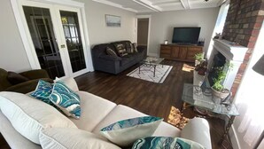 A living room with a sofa, a television, and a fireplace.