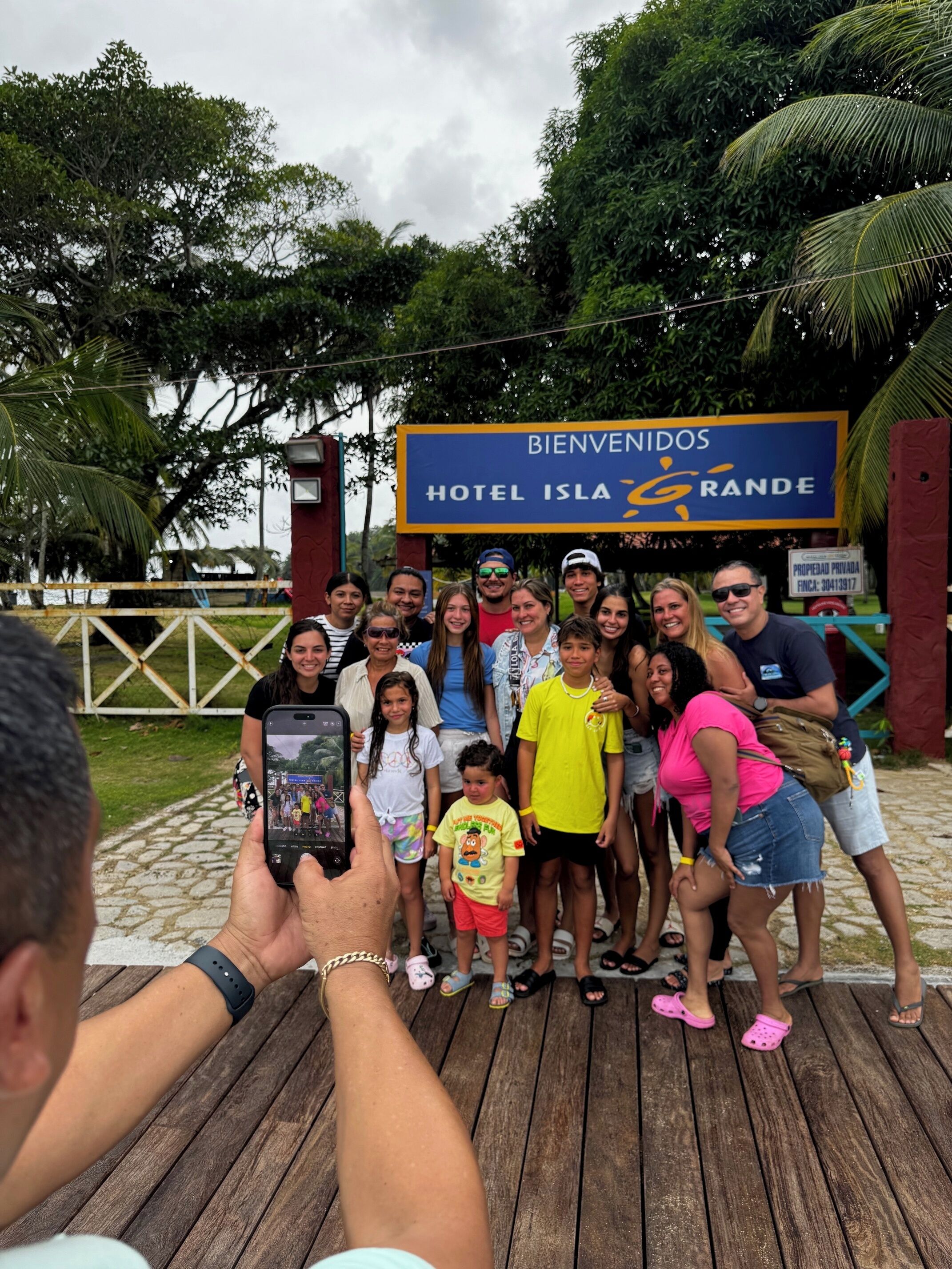 Un grupo de personas posando frente a un letrero que dice "BIENVENIDOS HOTEL ISLA GRANDE".