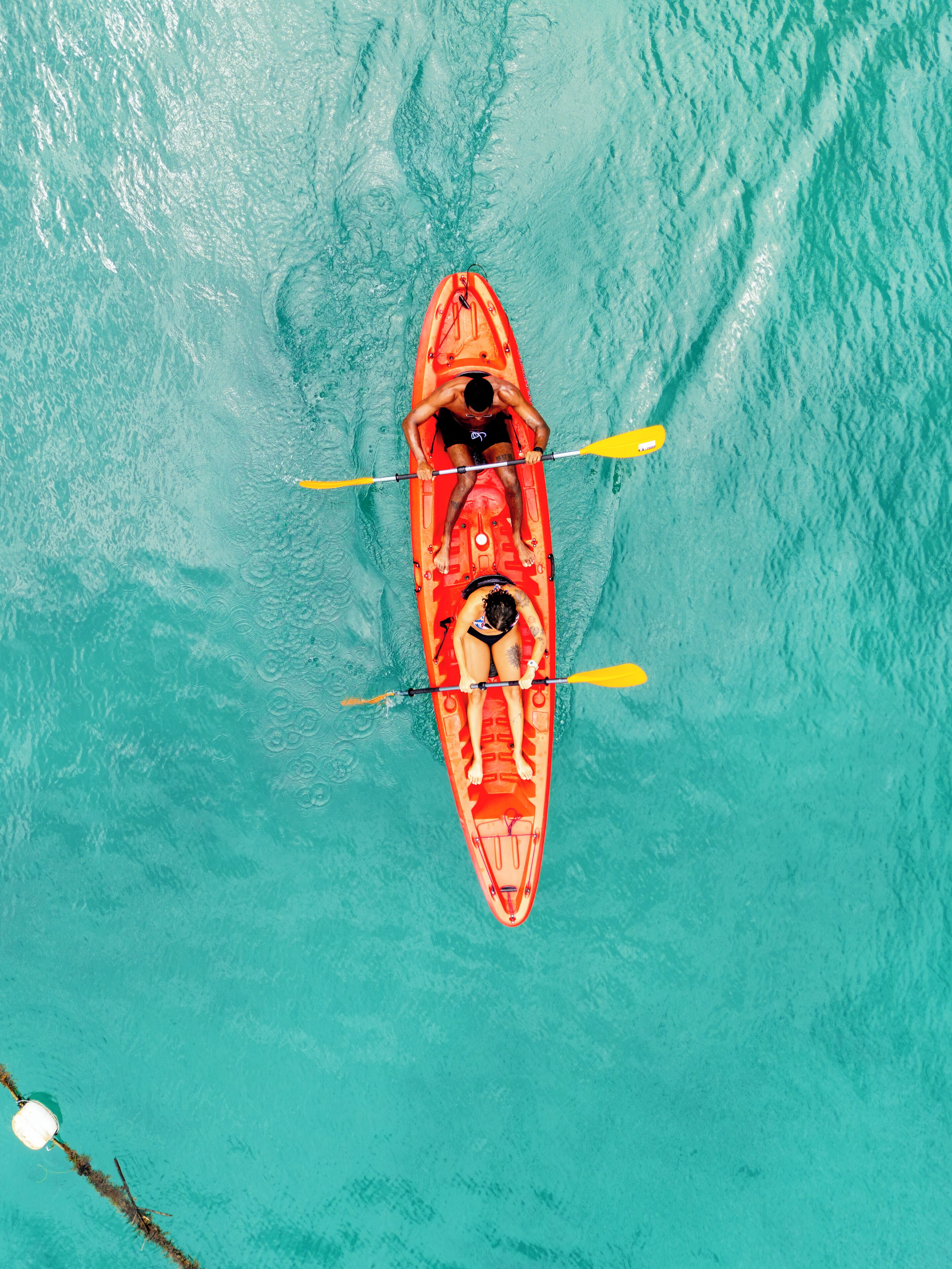 Vista aérea de un kayak rojo sobre aguas turquesas.