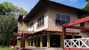 A two-story house with a tiled roof, a covered porch, and a red and white fence. - HOTEL ISLA GRANDE  (Isla Grande)