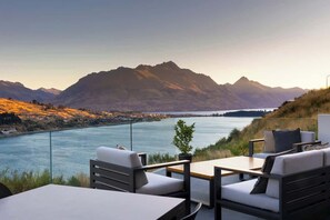 Terraza con asientos exteriores con vistas a un río y montañas.