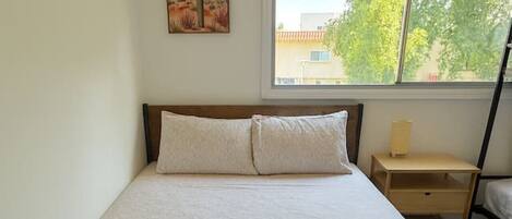 Escritorio, tabla de planchar con plancha, wifi y ropa de cama