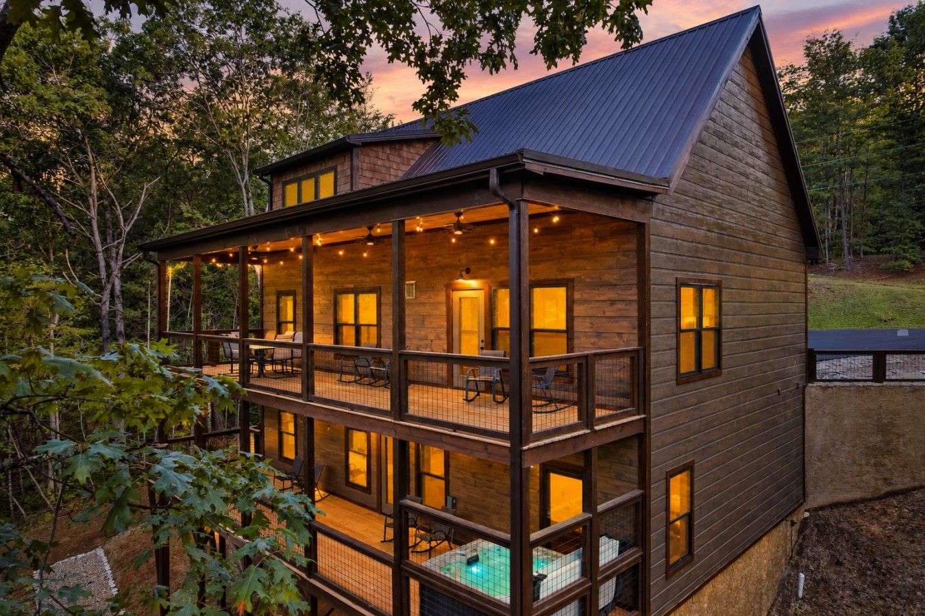 A two-story wooden cabin with a balcony, a pool, and multiple windows.