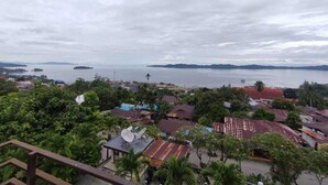 Un pueblo costero con casas, una antena parabólica y vistas al mar y a islas distantes.