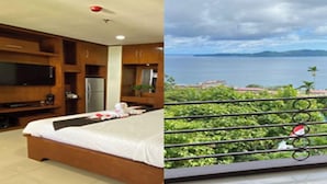 Un dormitorio con cama, televisión y vista al mar.
