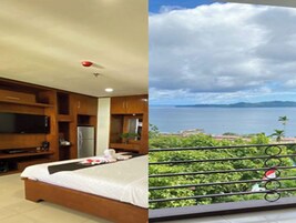 Un dormitorio con cama, televisión y vista al mar.