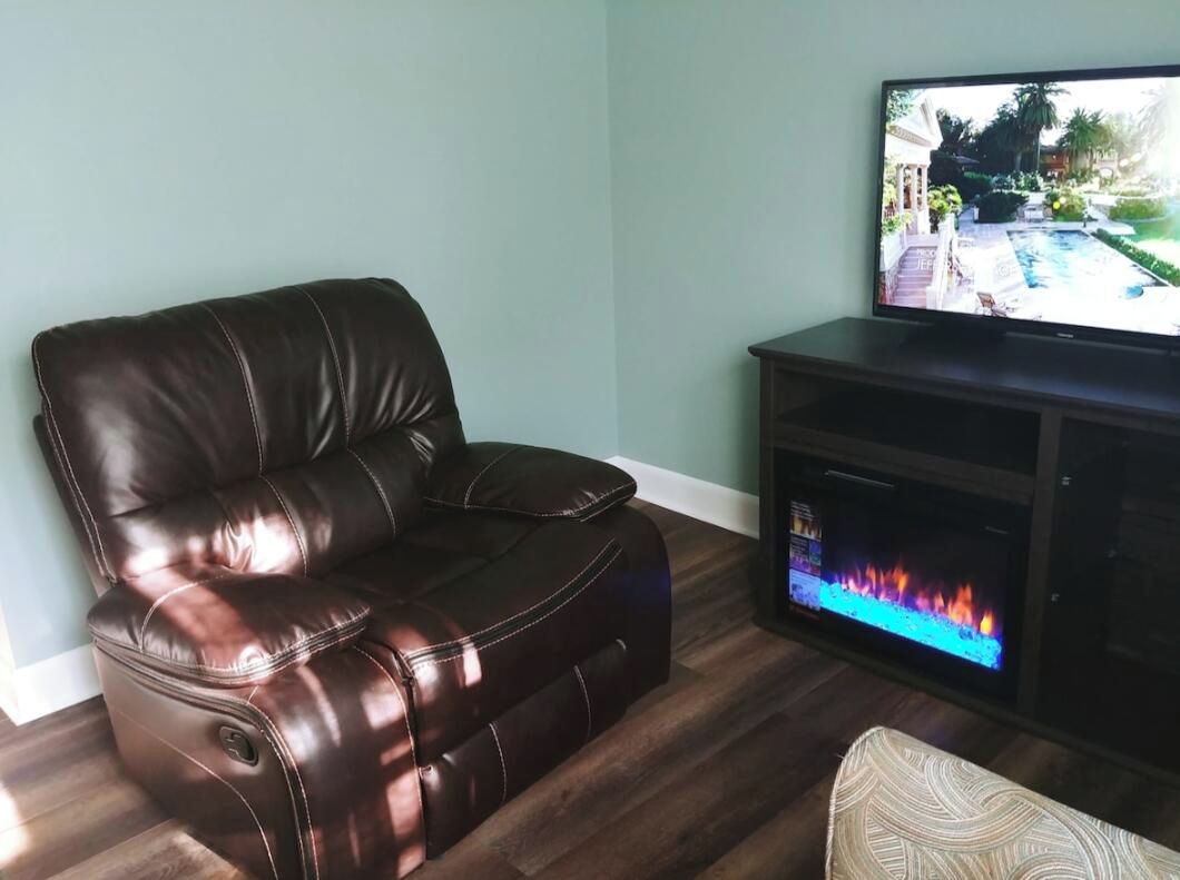A living room with a recliner chair and a fire place.