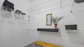 A laundry room with a wooden bench, a hanging rack, a shelf with a plant, and a framed picture on the wall. - Rustic Luxe Escape, Pool, Parking & Discounts! (Nashville)