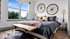 A bedroom with a large bed, a window, and two wall decorations. - Rustic Luxe Escape, Pool, Parking & Discounts! (Nashville)