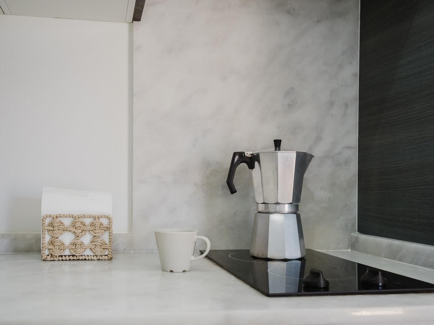 Een keukentrap met een koffiezetapparaat, een mok en een decoratieve doos.