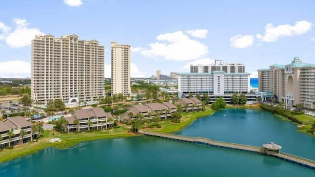 A resort with multiple high-rise buildings, a central water body, and a dock. - Ariel Dunes II in Seascape Resort! 405 (Miramar Beach)