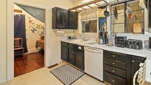 A kitchen with dark cabinets, a white countertop, and a ceiling fan.