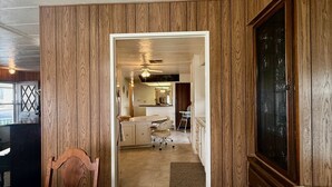 A hotel room with a wooden wall panel, a bed, a desk, and a TV.