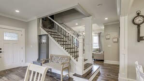 Un escalier avec une rampe en bois et des balustres noires, menant à l’étage supérieur.