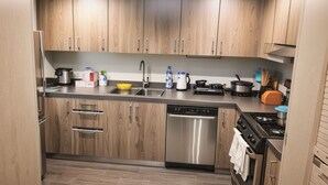 Una cocina moderna con armarios de madera, electrodomésticos de acero inoxidable y salpicadero de azulejos.