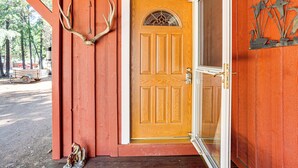 Une porte en bois avec un panneau de verre et un élément décoratif en métal au-dessus.