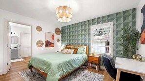 Une chambre à coucher comprenant un lit, une table de chevet, une lampe et un bureau avec une chaise.