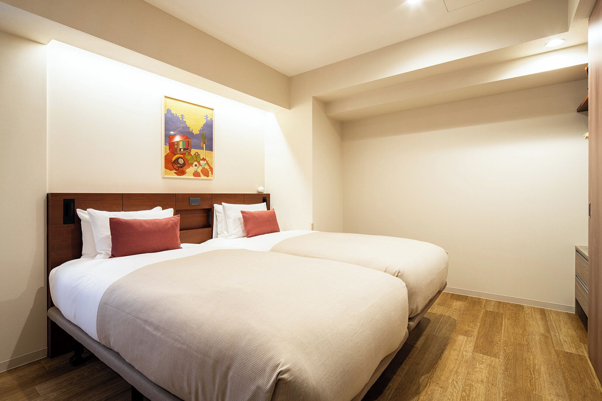 A hotel room with a double bed, a bedside table, and a wall-mounted TV.