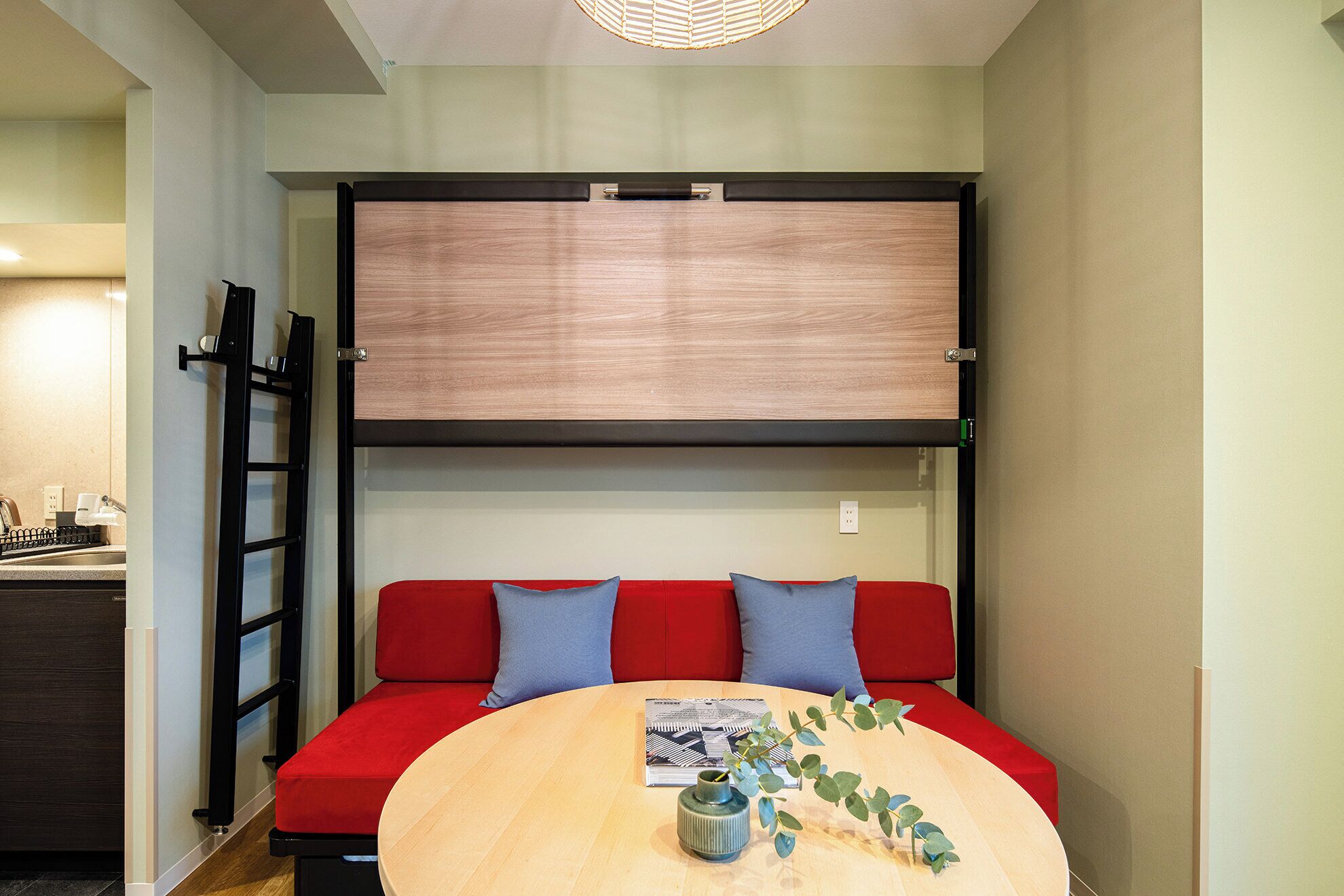 A compact living space with a sofa, a small table, and a wall-mounted TV.