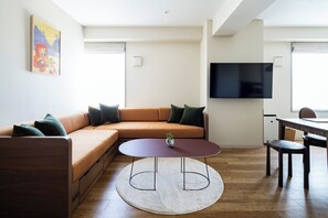 サウナ スイート | リビング エリア | 43 インチのスマートテレビ (衛星放送視聴可)、書庫