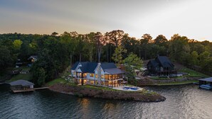A large house with a pool, surrounded by water and trees. - Luxe Lake Martin Home  Pool Hot Tub  Boat Dock (Dadeville)