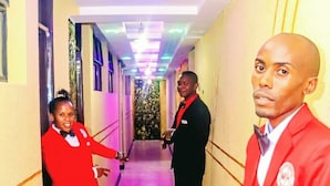 A hotel corridor with a polished floor, a ceiling with recessed lighting, and a wall with a logo. - Machakos inn hotel  (Machakos)