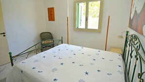 A bedroom with a bed, a chair, a window, and a door. - Casa Nima: A welcoming independent house situated at a short distance from the beach, with Free WI-FI. (Patù)