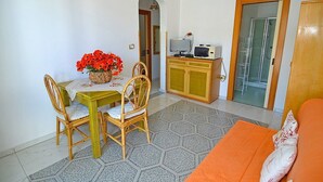 A compact living space with a dining area, a sofa, and a small kitchenette. - Casa Nima: A welcoming independent house situated at a short distance from the beach, with Free WI-FI. (Patù)