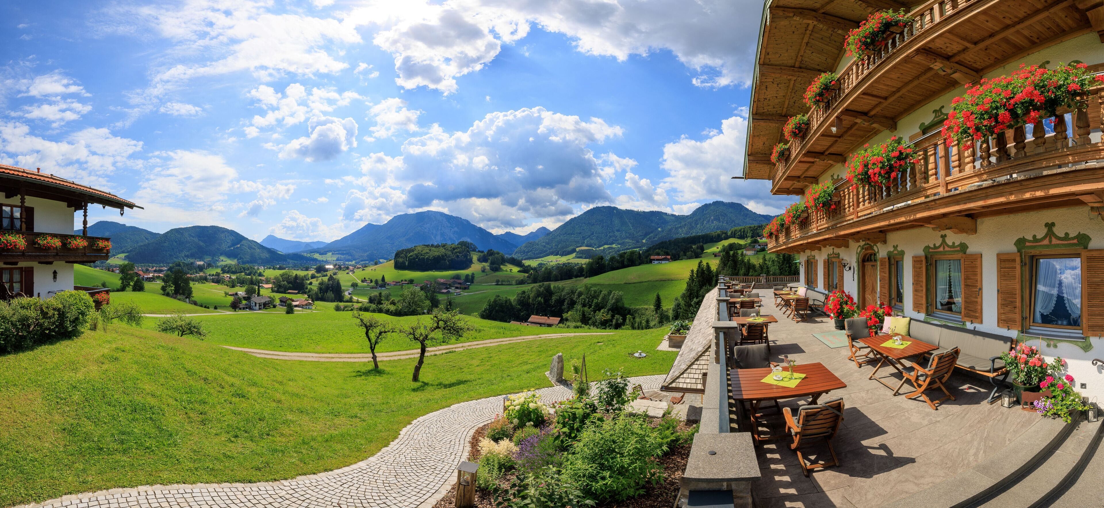Eine Terrasse mit Sitzgelegenheiten im Freien mit Blick auf ein malerisches Tal und Berge.