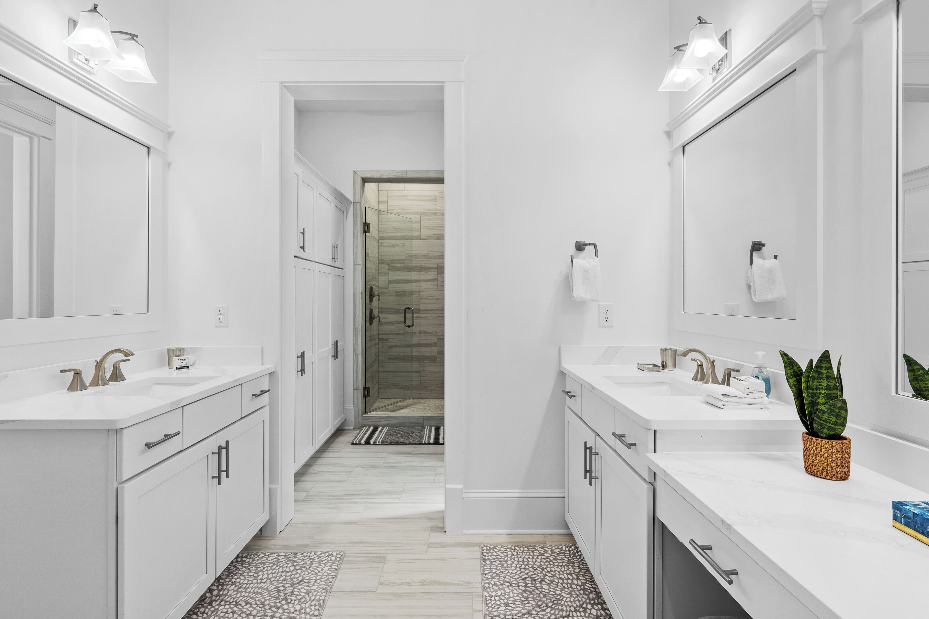 A modern bathroom with two sinks, a shower, and a walk-in shower.