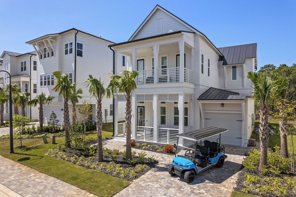 A two-story house with a covered porch and a garage. - Sleeps 20 | 2 Homes, 9BDR, Arcade | Walk to Blue Mountain Beach Access & Eats (Santa Rosa Beach)
