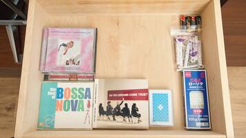 A wooden drawer containing various items including a CD, a book, a candle, and a small box.