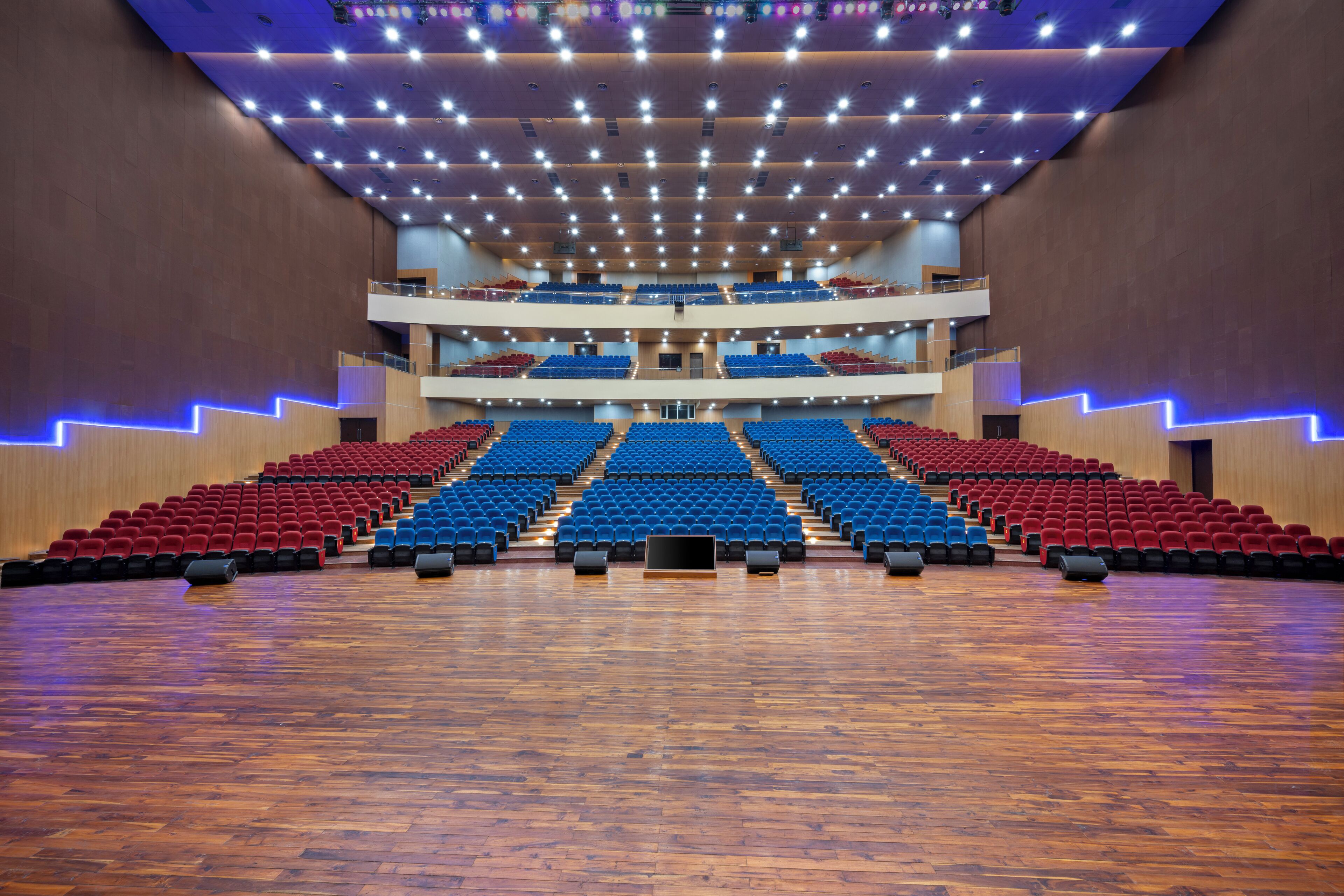 Un auditorio de varios niveles con asientos escalonados y un escenario central.