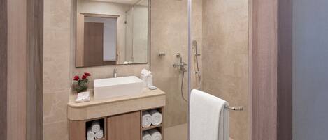 A modern bathroom with a large mirror, a sink, and a shower.