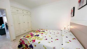 A bedroom with a bed, a wardrobe, and a nightstand.
