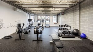 A gym with treadmills, dumbbells, and exercise balls.