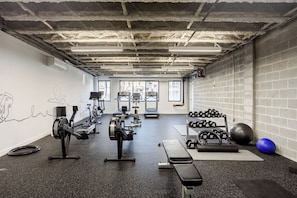 A gym with treadmills, dumbbells, and exercise balls.