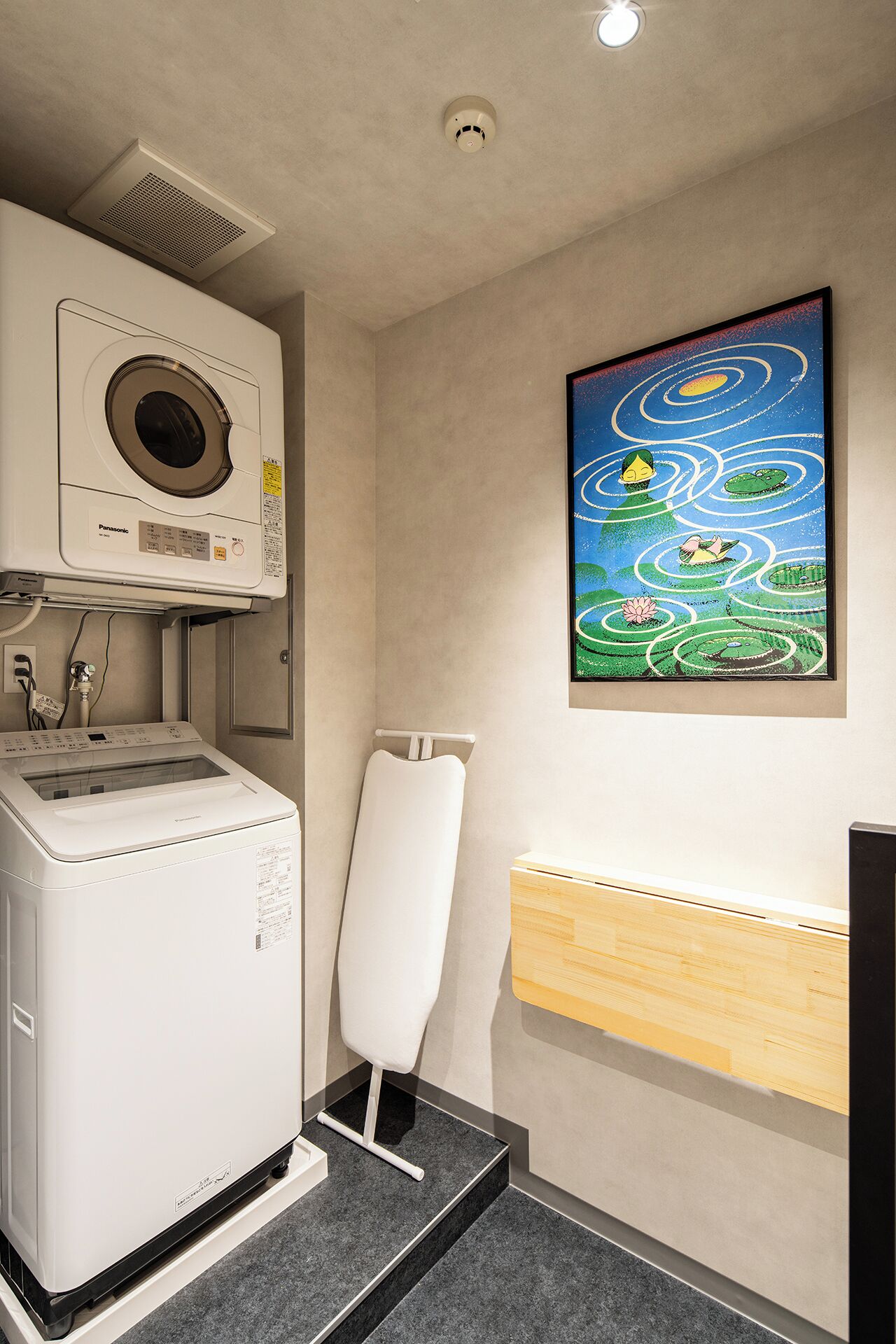 Une buanderie équipée d’un lave-linge, d’un sèche-linge et d’un porte-serviettes fixé au mur.