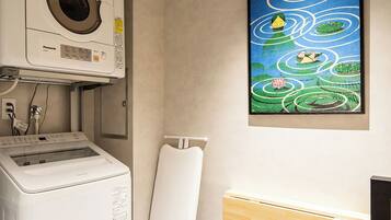 Une buanderie équipée d’un lave-linge, d’un sèche-linge et d’un porte-serviettes fixé au mur.