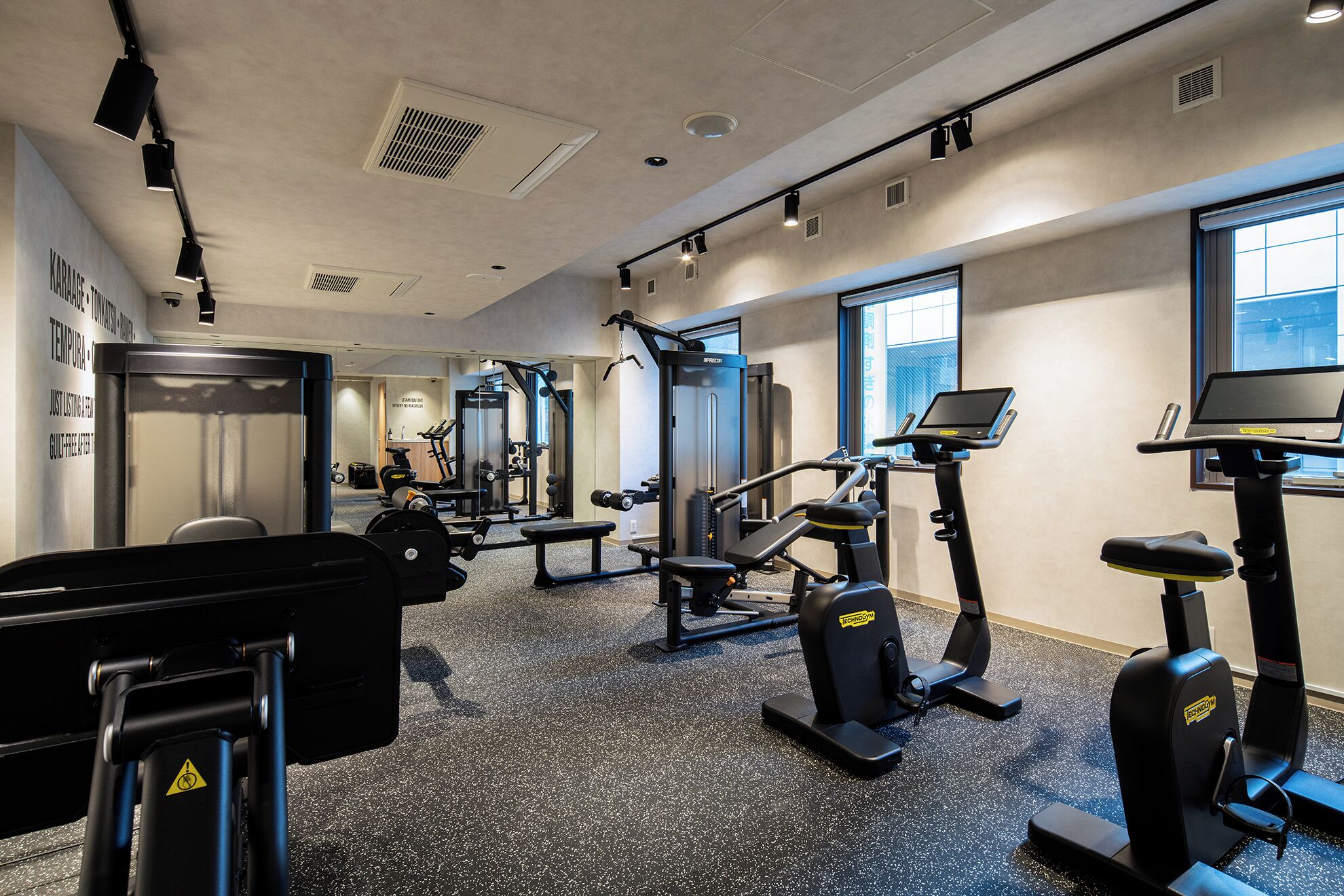 Un gimnasio con diferentes equipos de ejercicio, incluyendo cintas de correr y máquinas de pesas.
