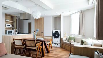 Un espacio moderno para vivir con comedor, cocina y lavadora.