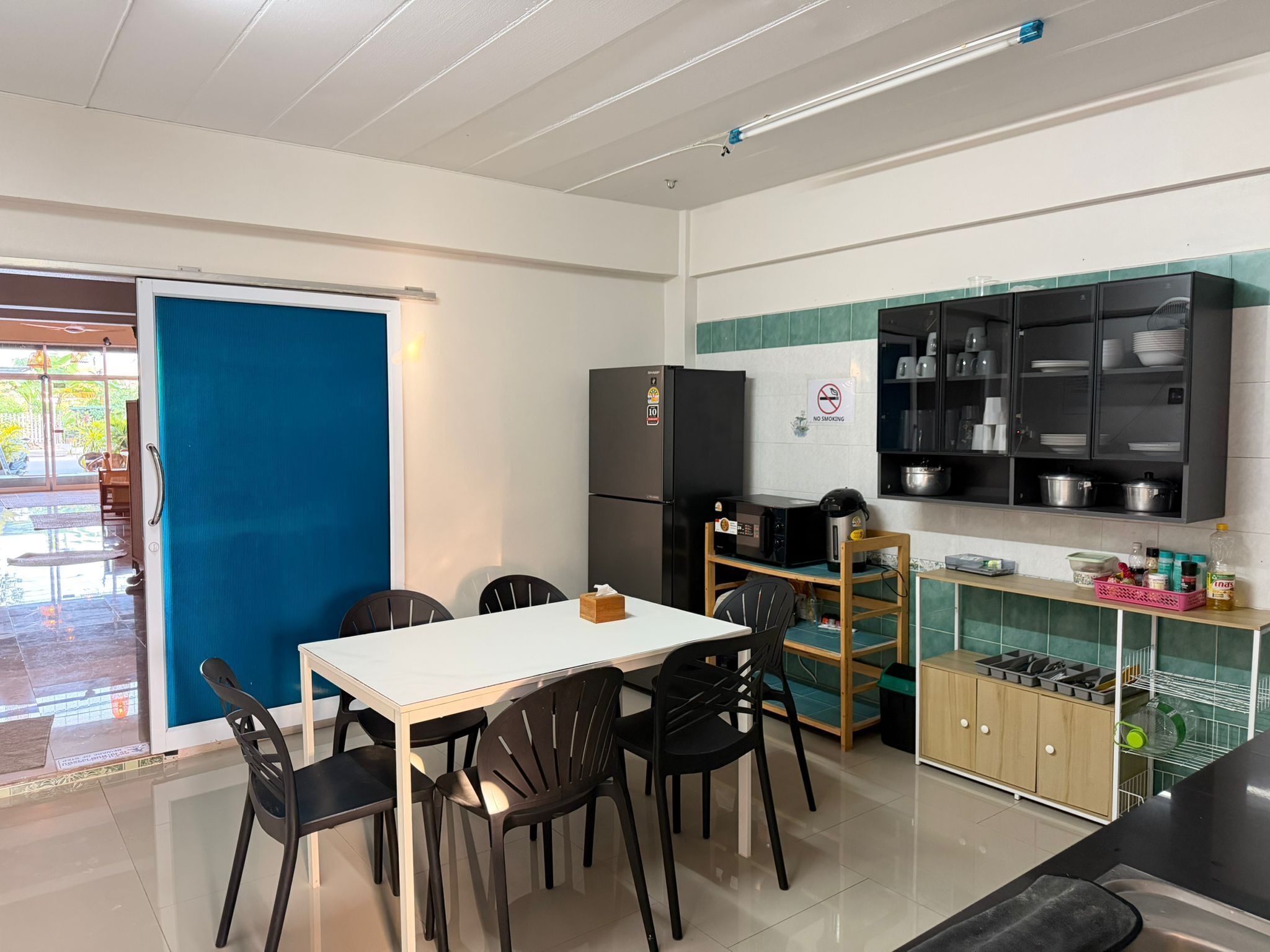 Una cocina compacta con refrigerador, microondas y gabinetes de madera.