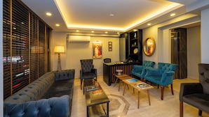 A modern living room with a sofa, armchairs, a coffee table, and a fireplace.