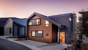 A modern two-story house with a wooden facade and a stone accent wall. - Luxury Mountain Chalet one of Crackenback's best (Crackenback)