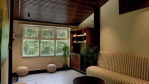 Uma sala de estar moderna com uma janela grande, um sofá, uma mesa de centro e um armário de madeira.