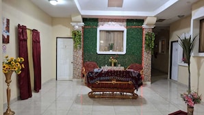 A hotel room with a bed, a small table with a vase of flowers, and a potted plant. - Hostal Casa Habana  (Managua)