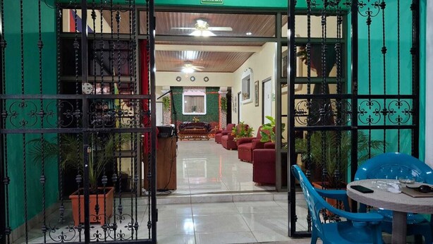 A hotel lobby with a central seating area, a reception desk, and a ceiling fan. - Hostal Casa Habana  (Managua)