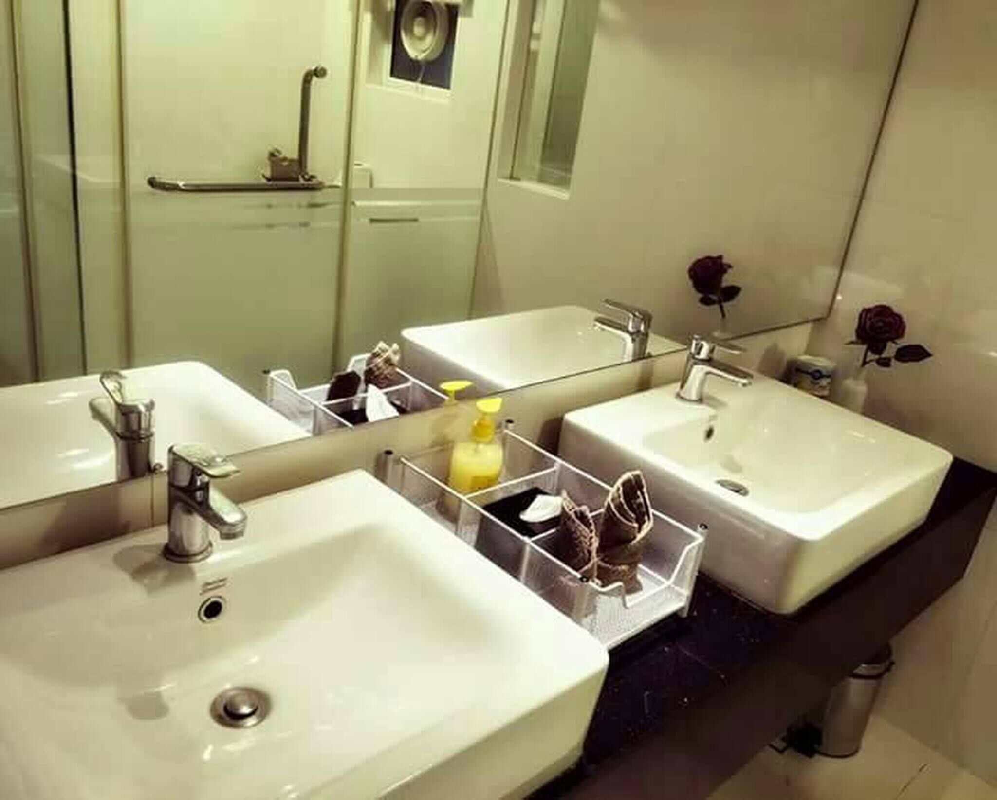 Un baño con dos lavamanos, un espejo y zona de ducha.