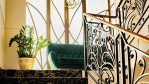 A staircase with ornate black metal railings and patterned carpet.