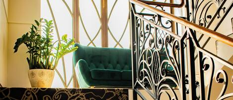 A staircase with ornate black metal railings and patterned carpet.
